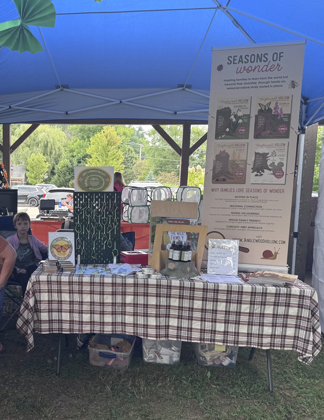 Seasons of Wonder vendor booth with books and nature crafts