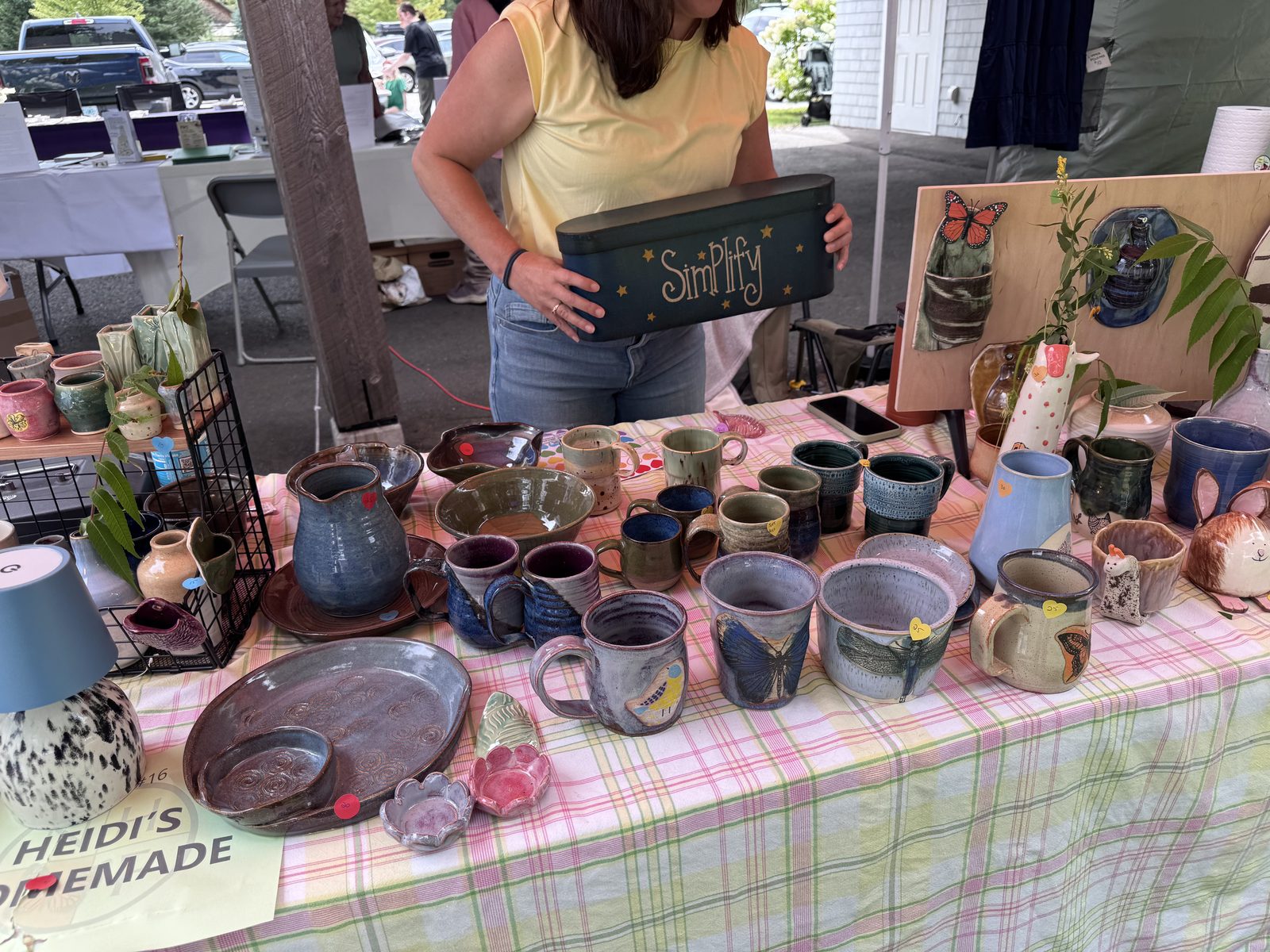 Pottery vendor table with handmade mugs and dishware