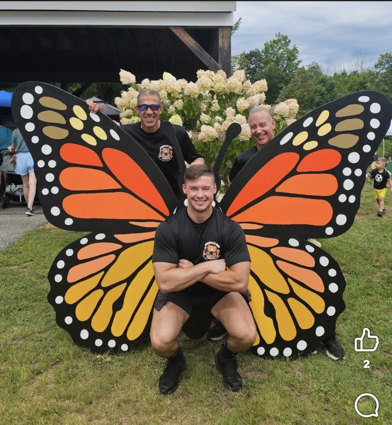 Festival volunteers posing with a giant monarch butterfly wing cutout